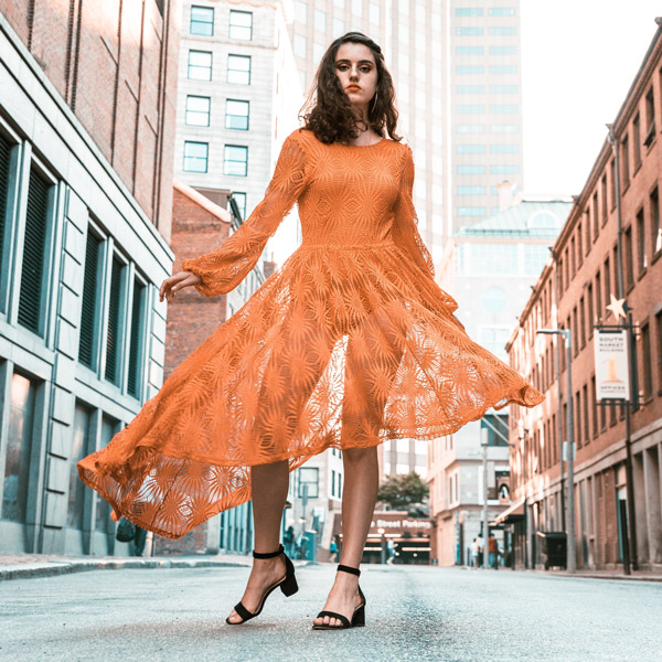 women in a city street wearing an altered orange dress